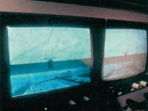 Surveillance de la tenue du pantographe au cours de l’essai, à l’aide de deux écrans reliés à des caméras placées sur le toit de la rame. Sur la vue de détail, on remarque au bas de l’écran les indications kilométrique (156,8) et de vitesse (366). © CAV-SNCF - P. Olivain